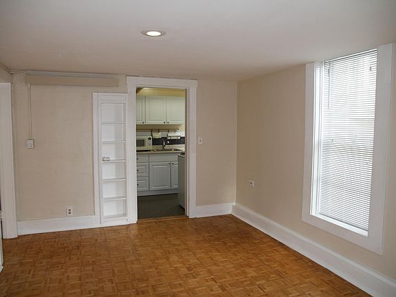 Large living room with natural light, hardwood floors and built-ins