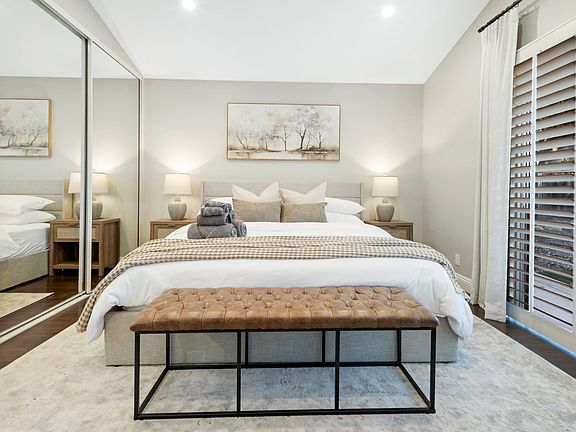 The primary bedroom features a cozy king bed with plush linens, nightstands with built-in charging stations for convenience, ensuring devices are always ready. Blackout curtains ensure a restful sleep by blocking out light for a peaceful atmosphere.