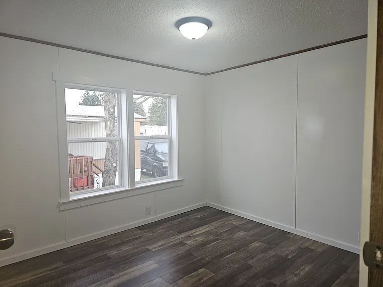 2nd bedroom with brand new vinyl windows, new wood vinyl plank flooring, new trim, new light fixture, and freshly painted.