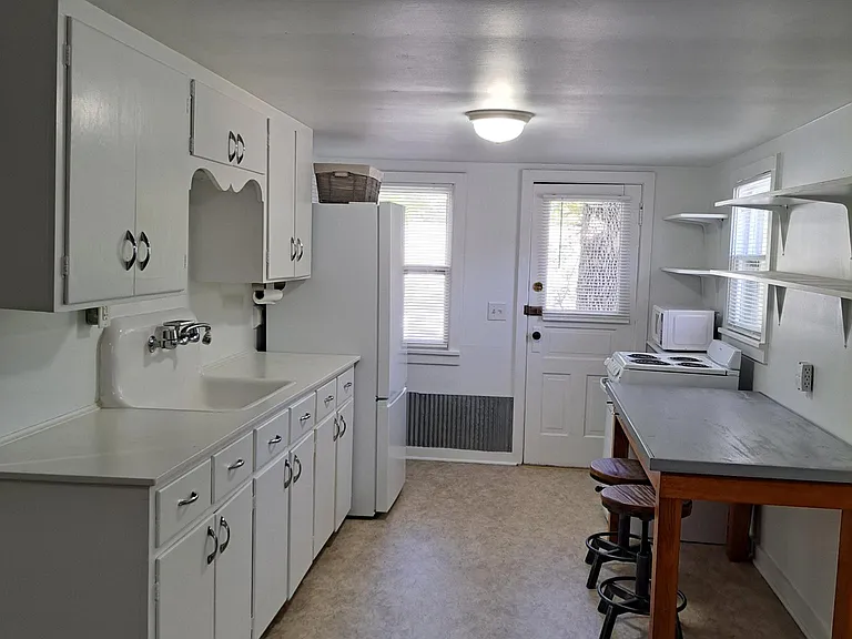 Kitchen with great storage. Eat in work area and table with stools.