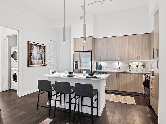 Kitchen with oak cabinetry, undercabinet lighting, white quartz countertops, and hard-surface vinyl plank flooring