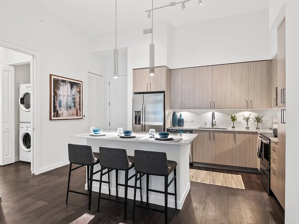 Kitchen with oak cabinetry, undercabinet lighting, white quartz countertops, and hard-surface vinyl plank flooring