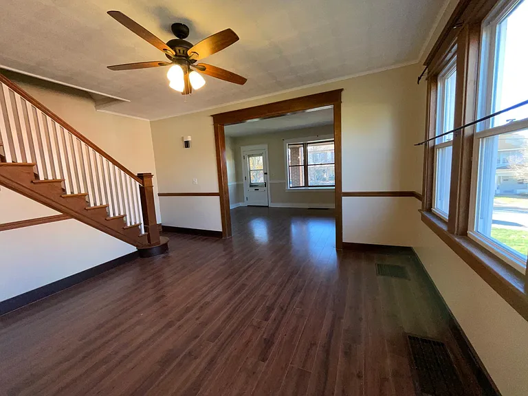 Large dining room with wide stairs to second floor, flows into front living room.