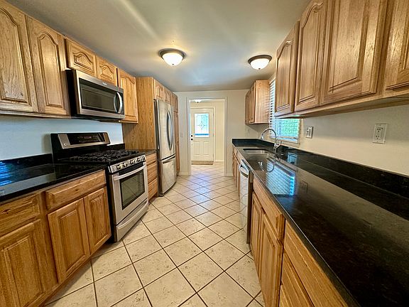 Granite and Stainless Kitchen with Hickory Wood Cabinets and Pantry. Gas range, dishwasher, refrigerator, microwave oven, disposal.