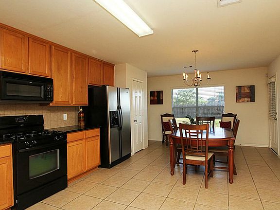 Kitchen features granite counters and beautiful black appliances.