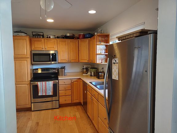 Kitchen view showing microwave and oven, pantry.