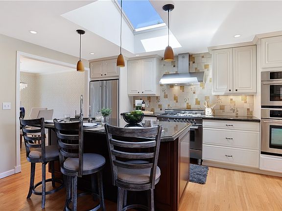 You are going to LOVE this chef's kitchen! Notice the beautiful backsplash, soft-close cabinets, underlet lighting, and the awesome island with sink and breakfast bar where you can sit and keep the cook company! 