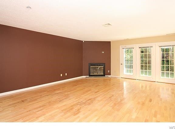 Large living room with wood burning fireplace and french doors leading out to your own private patio