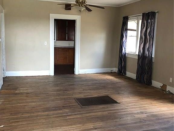 Large living room with original floors. Needs work because floors have damage.