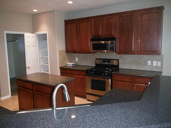 Kitchen features stainless steel appliances, island kitchen, in room pantry, lots of cabinets for storage and lots of counter space area ideal for any iron chef!