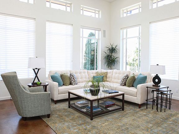 The formal living room is located directly left of the front entry foyer. Note the transom windows running parallel to the larger windows.