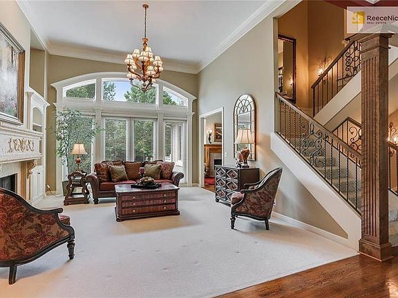Great Room with fireplace and wall of windows overlooking treed backyard.