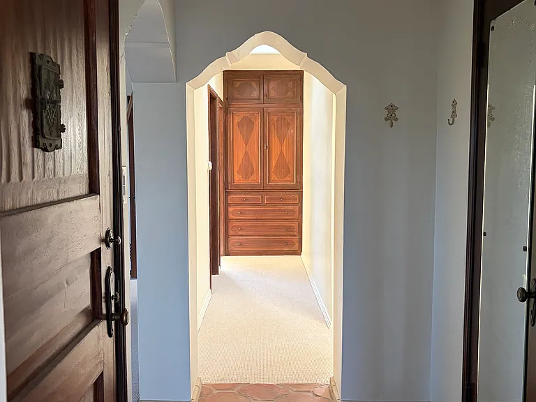 Hallway to the linen closet with a skylight above