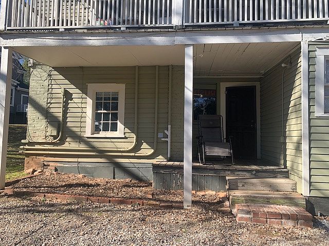 Entry with covered porch, parking and yard space.