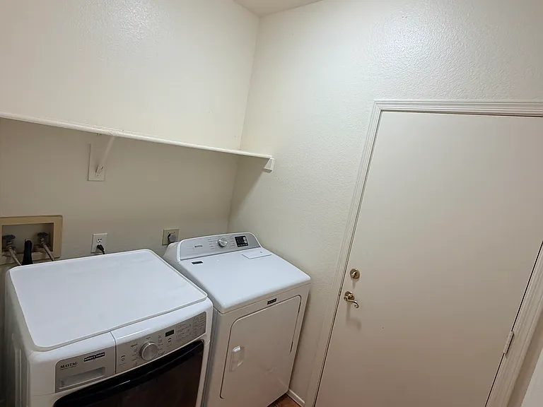 dedicated laundry room featuring washer/dryer and storage shelving