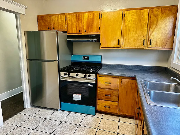 Beutiful kitchen with lots of wood cabinets for storage and cooking.