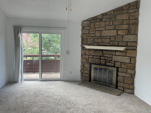 Living room opens to deck, newer double-pane patio doors, wood burning fireplace