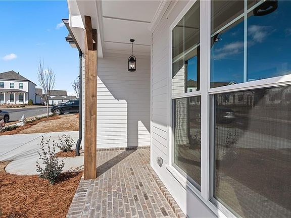 Large brick front welcoming porch with stained columns.
