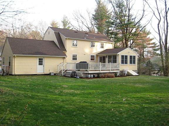 Large mahogany deck overlooks lovely manicured grounds on near acre!