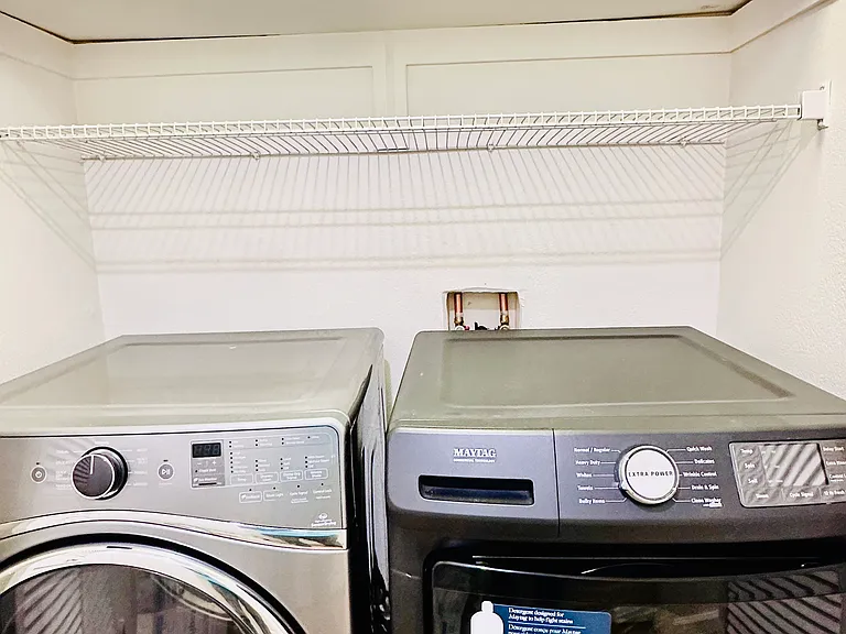 In unit full sized washer and dryer with plenty of storage space above