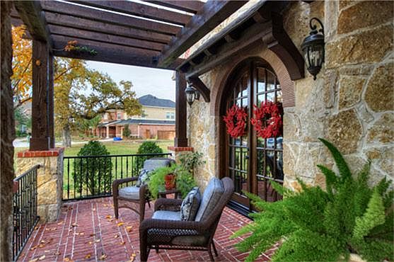 Cozy front porch greets you upon arrival with beautiful cedar beams and arched french doors that lea