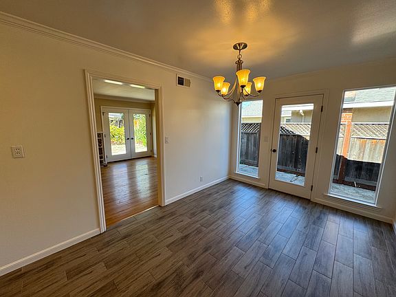 Dining area looking into living room. Tile floor in dining area, hardwood in living room.