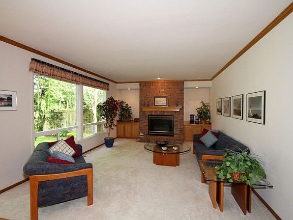 Spacious Family Room adjacent to Kitchen provides additional warmth from cozy, gas-log, brick faced fireplace, flanked by built-in cabinetry, and offering tranquil views of the back yard and forest beyond.