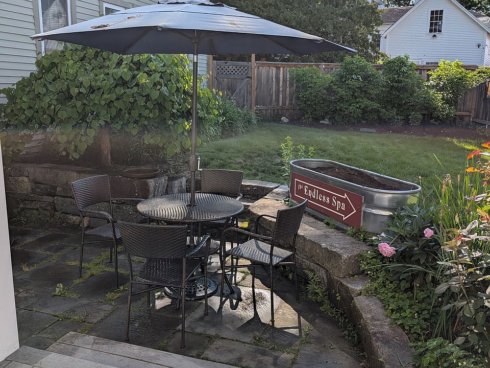 Fenced in yard with sunken stone grilling and dining space
