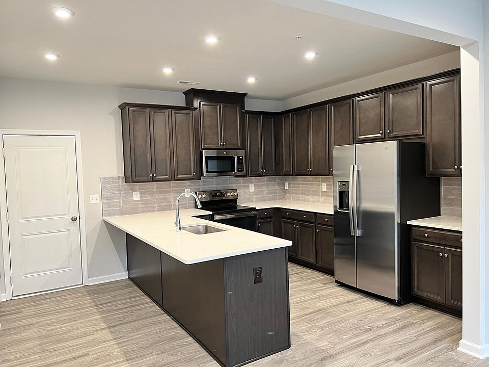 Quartz countertops and stainless steel appliances with eat at peninsula