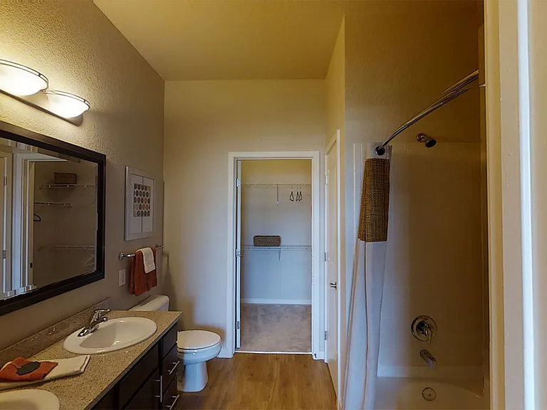 Apartment bathroom with wood-style flooring.