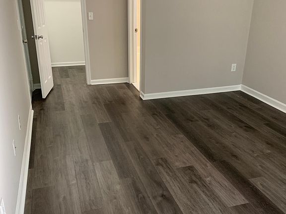 Primary bedroom looking at closet (left) and bathroom door (right)