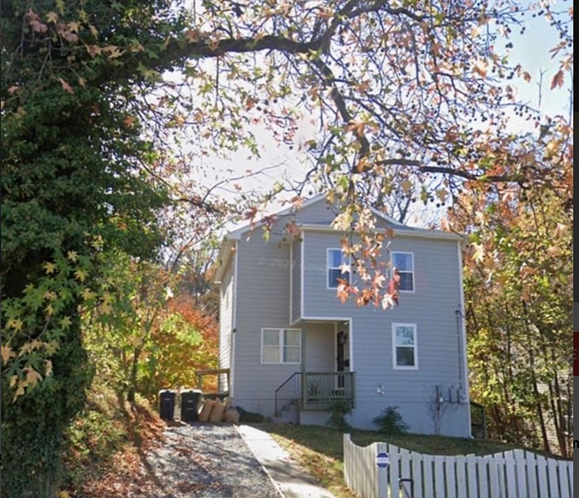 Front Exterior w/ 2-car Driveway. Semi-fenced front yard with dogwood and crape myrtle trees and hosta ground cover.