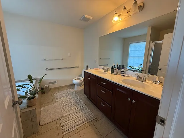 Master bath with dual sink and grab bar.