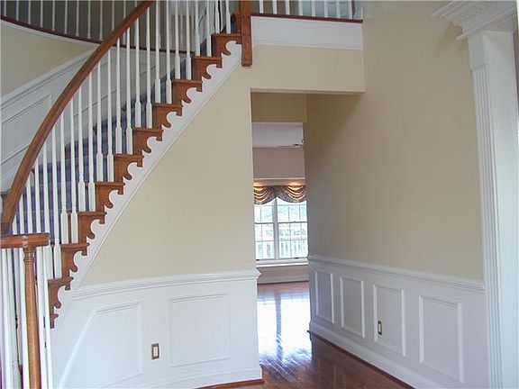 Foyer with curved staircase and hardwood floors