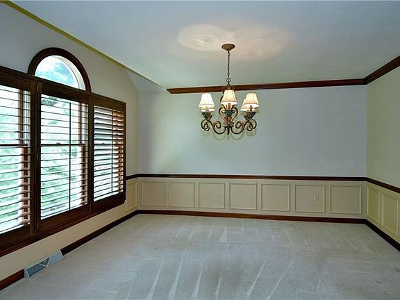Dining Room open to the living room and kitchen.  Nice wainscoting and wood plantation shutters.  Brand new carpeting in this ro