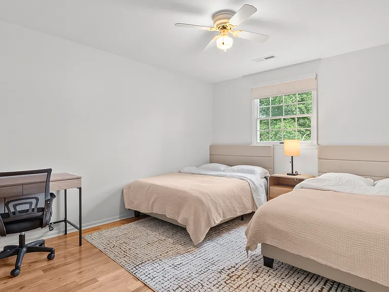 Upper-level bedroom with two full beds, two writing desks, and generous closet space.