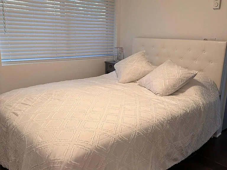 Full size bed and mattress with sheets and cover.