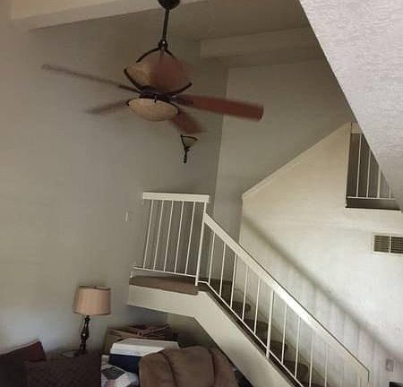 vaulted ceiling in family room with ceiling fan