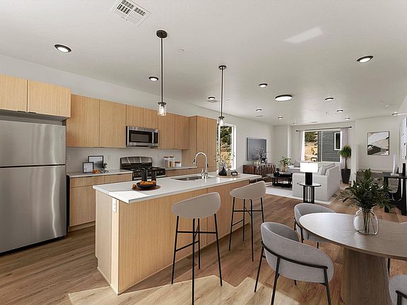 Bright and modern open-plan kitchen and living area featuring sleek wooden cabinets, stainless steel appliances, and elegant lighting fixtures, perfect for stylish entertaining.