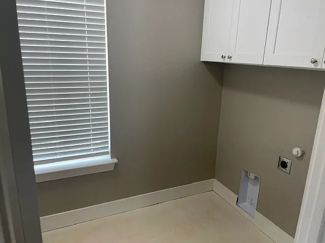 Laundry room with space for washer and dryer and plenty of storage.