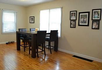 Entrance through side door leads into this open and bright dining room (11x8) with hardwood flooring.  This view is from the living room.