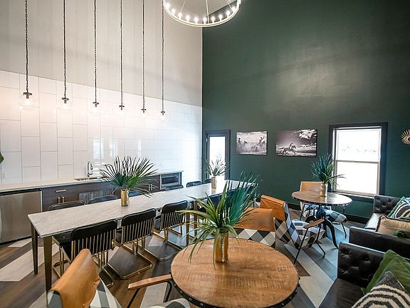 Clubhouse with high ceilings, kitchen with stainless steel appliances, and modern furniture.