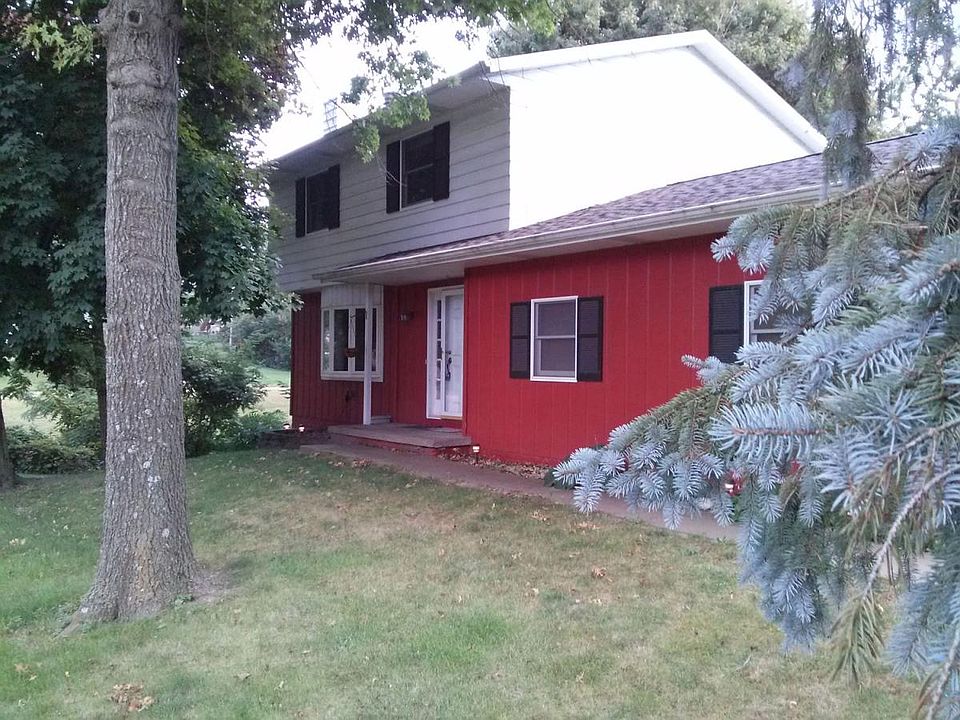 The front of the home with the living room bay window on the left and garage windows on the right. Above are the two windows for the smaller bedrooms.