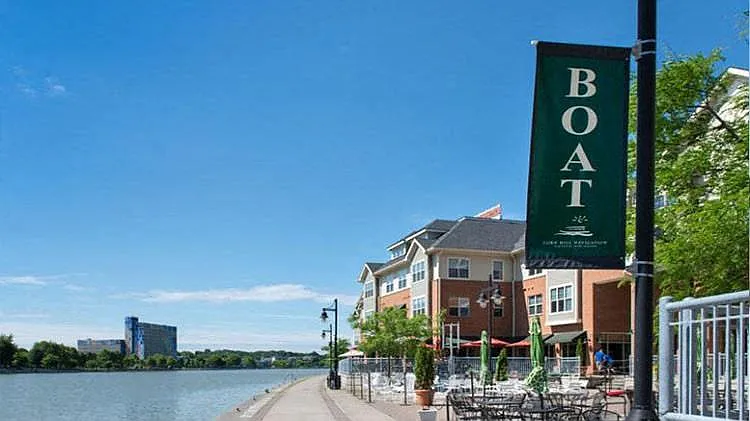 View of outdoor restaurant dining areas along the Genesee River at Corn Hill Landing and apartments above the shops and restaurants