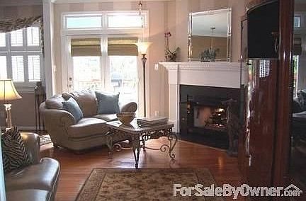 A Spacious, Warm Living Room : A gas log fireplace and hardwood floors make this living room warm an