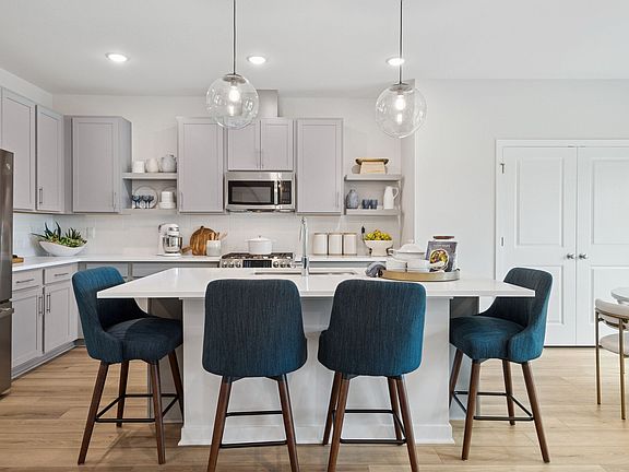 Kitchen with floating shelves and quartz countertops