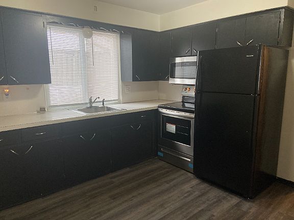 Kitchen with new appliances: stove, microwave, fridge.