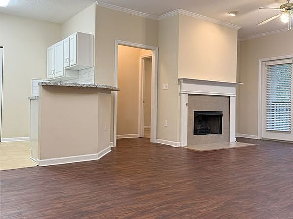 Great room features a gas fireplace and ceiling fan.