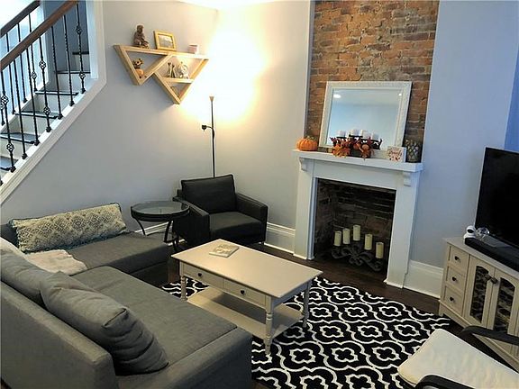 Living Room w/original mantle/fireplace and exposed brick!