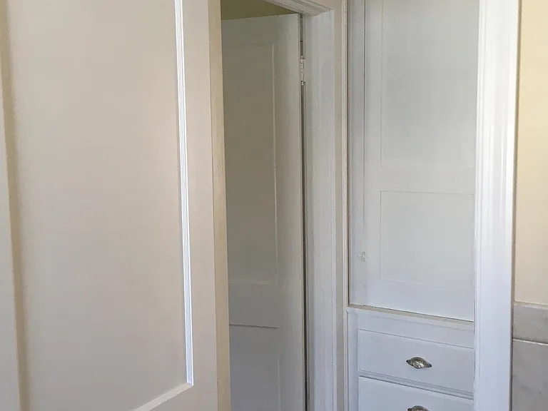 Large storage cabinet in hallway outside bathroom